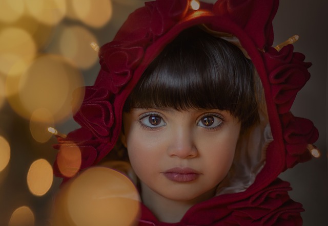 Portrét malého děvčete s červenou kápí na hlavě